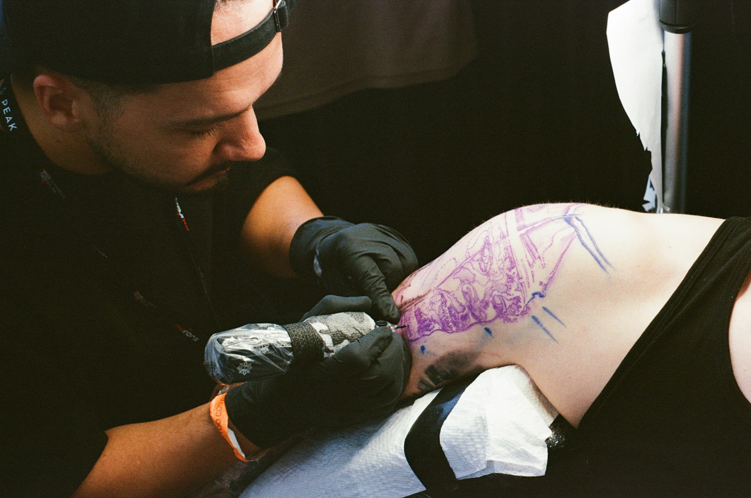 Tattoo artist working on a client's stencil